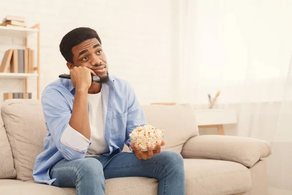Jonge man tv kijken, met behulp van de afstandsbediening om te schakelen van de kanalen — Stockfoto