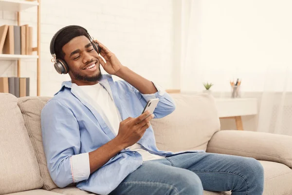 Stilig ung man i hörlurar Lyssna på musik på telefonen — Stockfoto
