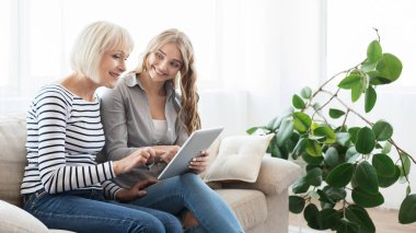 Olgun Anne ve dijital tablet ile yetişkin kızı