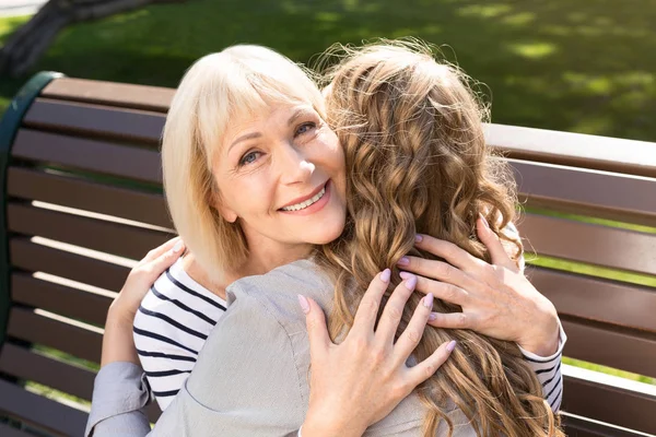 Lycklig senior mamma kramas med dotter i park — Stockfoto