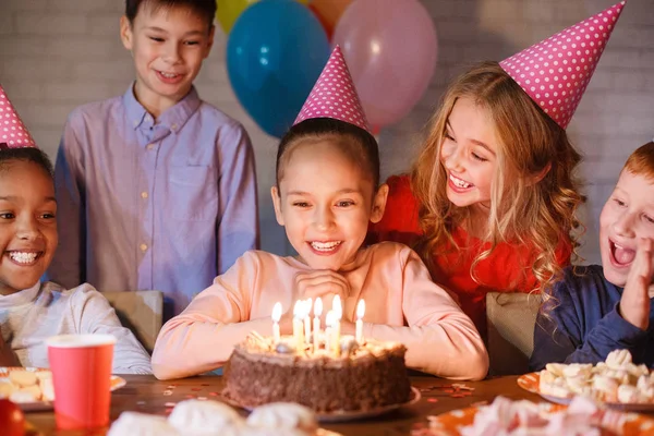 Mädchen schaut Geburtstagstorte mit Kerzen an — Stockfoto