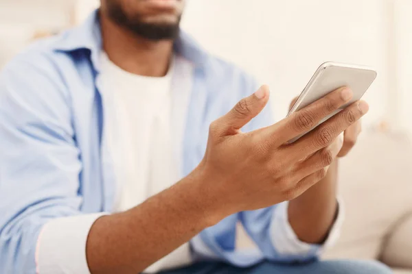 Afrikalı-Amerikalı adam yeni smartphone elinde tutan — Stok fotoğraf