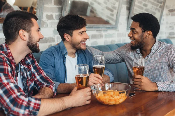 Друзья пьют пиво и отдыхают в баре — стоковое фото