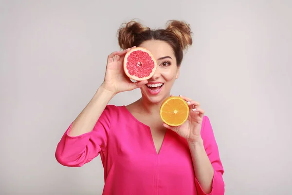 Mulher feliz se divertindo com metades de citrinos — Fotografia de Stock