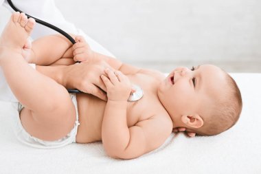 Doktor stetoskop kliniği ile küçük bebek incelenmesi.