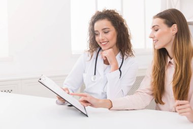 Kişiselleştirilmiş diyet planı hastaya açıklayan beslenme uzmanı