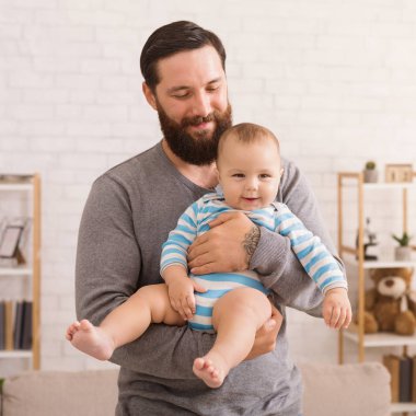 Sevgi dolu babası şirin bebek oğlu kucaklayan
