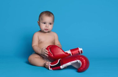 Büyük kırmızı boks eldivenli küçük bebek