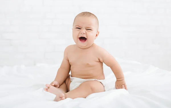 Schattige huilende babyjongen op bed in de ochtend — Stockfoto