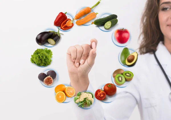 Mão de médico nutricionista mostrando pílula em símbolos frutas — Fotografia de Stock