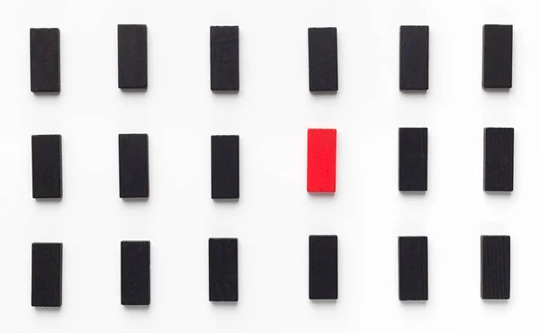 Красный деревянный блок между черными и белыми — стоковое фото