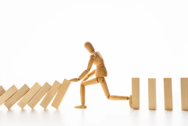 Wooden mannequin stopping domino effect on white — Stock Photo, Image