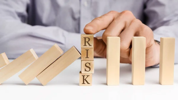 Бізнесмен зупинити ефект доміно зі словом Ризик — стокове фото