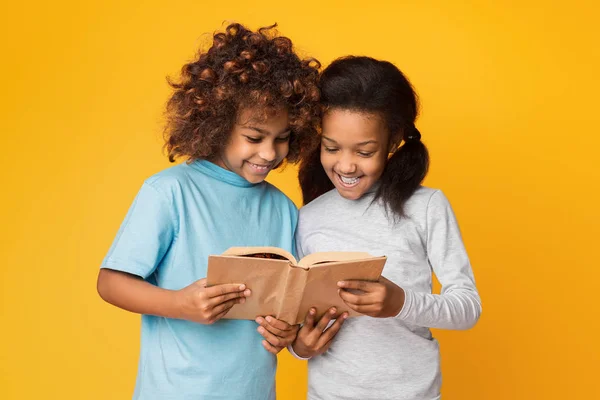 Милые девочки читают книжки у стены — стоковое фото