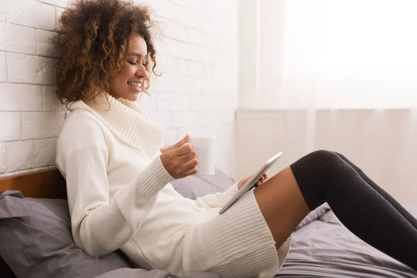 Расслабленная женщина с цифровым планшетом и чашкой кофе — стоковое фото