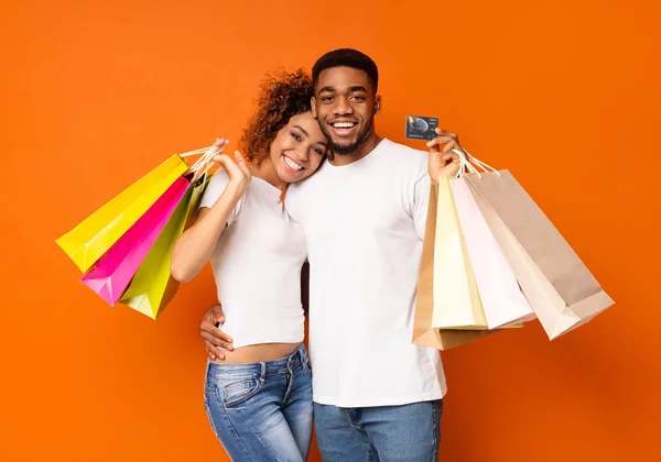 Junges schwarzes Paar mit Einkaufstaschen und Kreditkarte — Stockfoto