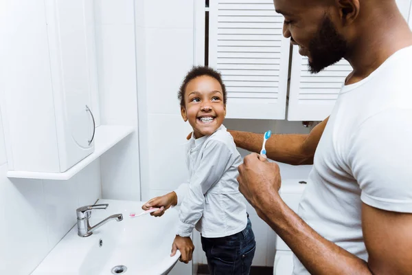 Gadis Afrika-Amerika menyikat gigi dengan ayah bersama-sama — Stok Foto