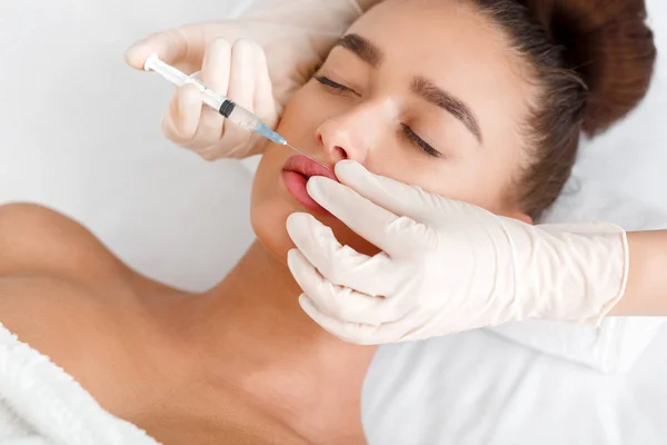 Beauty injection. Woman making correction form the upper lip