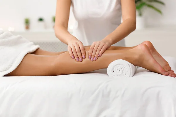 Massagista massagista mulher bezerros no centro de spa — Fotografia de Stock
