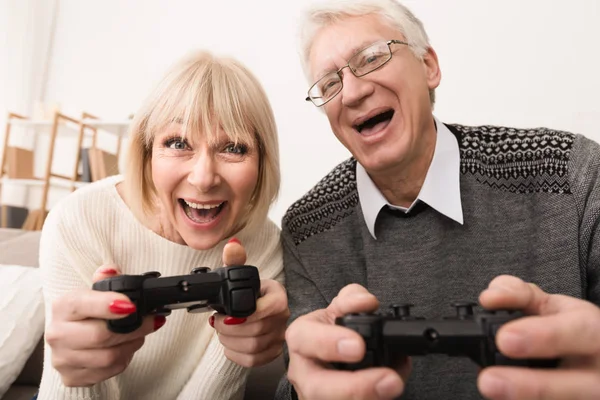 Pareja mayor jugando videojuegos juntos en casa — Foto de Stock