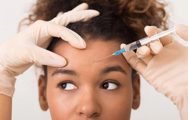 Femme afro-américaine se faire injecter du botox dans le front — Photo