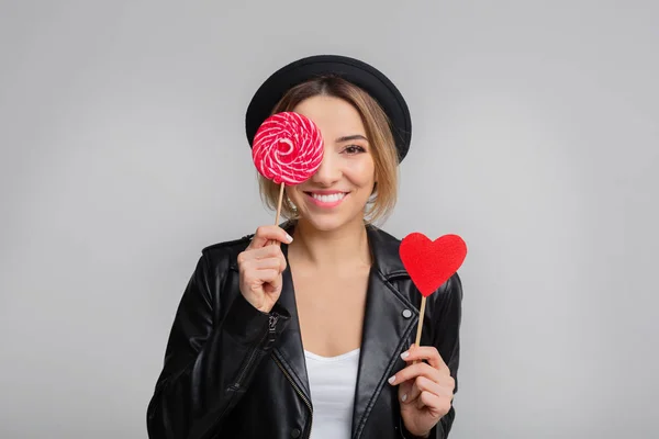 Joyful woman with lollipop and paper heart, having fun — Stock Fotó