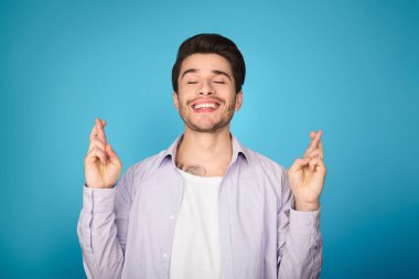 Genç adam ile kenetlenmiş parmaklar arka plan üzerinde dua