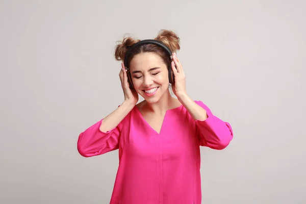 Vrouw luisteren muziek in hoofdtelefoons op achtergrond — Stockfoto