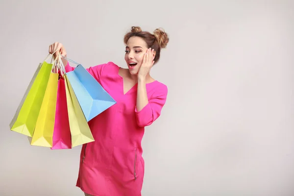 Überraschte Frau posiert mit Einkaufstüten und blickt in die Kamera — Stockfoto