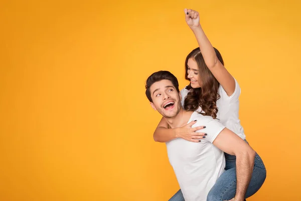 Verspieltes Paar im Huckepack-Stil macht Superman-Zeichen — Stockfoto