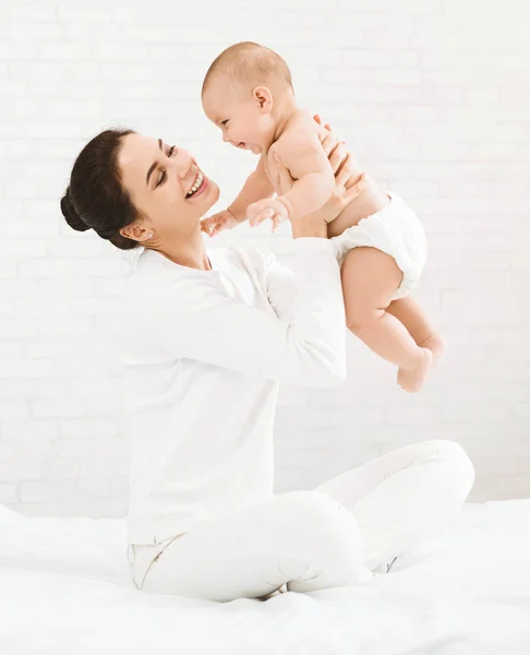 Ung mamma håller hennes happy baby i luften — Stockfoto