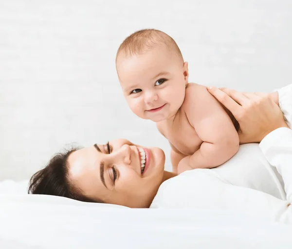 Mamma e bambino in pannolino che giocano in camera da letto — Foto Stock