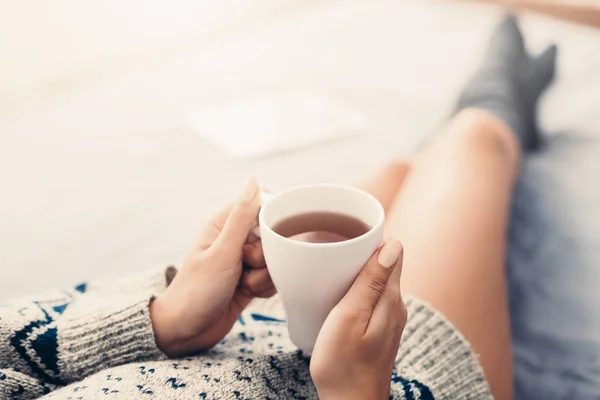 Женщина отдыхает в постели с чашкой чая — стоковое фото