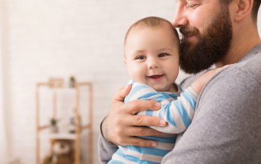 Sevgi dolu babası şirin bebek oğlu kucaklayan