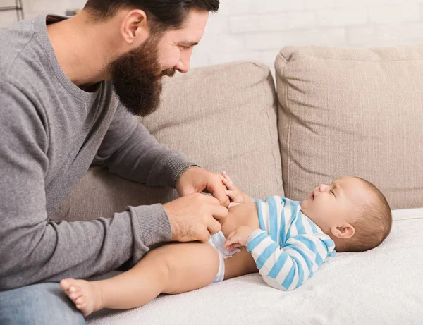Father changing diaper to his crying baby son — Stock Photo, Image