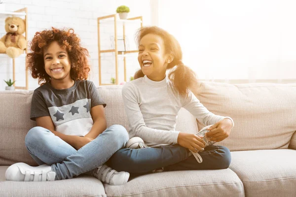 Glada afro-amerikanska tjejer sitter på soffan hemma — Stockfoto