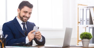 Mutlu işadamı Smartphone cep telefonu ile ofiste internet sörf