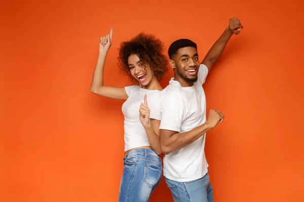 Joven pareja afroamericana encantadora posando sobre fondo naranja — Foto de Stock