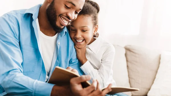 Pai e filha lendo livro juntos em casa — Fotografia de Stock