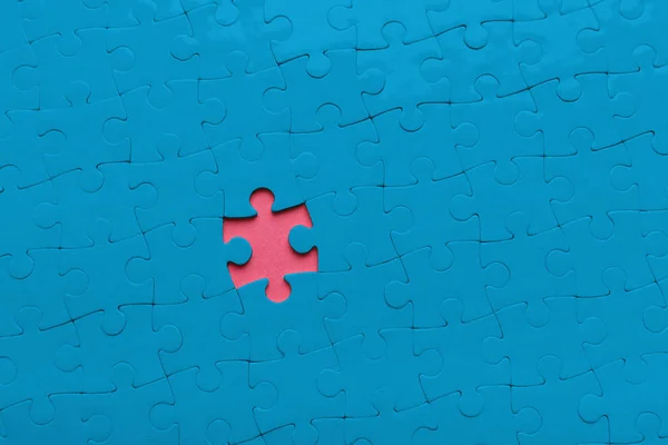 Foro rosa in sfondo puzzle blu, spazio di copia — Foto Stock