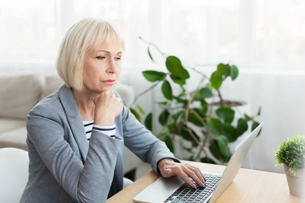 Elderly woman writer in white working on new article — Stock Photo, Image