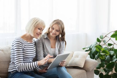 Kıdemli anne ve kızı internet tablet üzerinde tarama