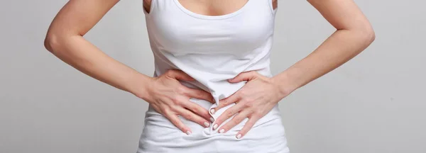 Mulher com dor de estômago, tendo intoxicação alimentar, fundo cinza — Fotografia de Stock