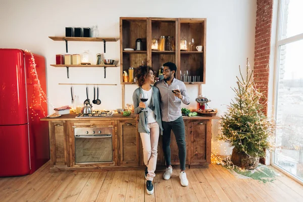 Ζευγάρι γιορτάζει τα Χριστούγεννα στην κουζίνα και να πίνει κρασί — Φωτογραφία Αρχείου