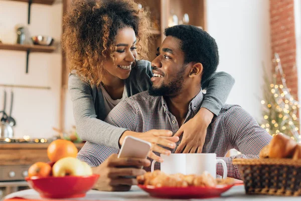 Amour jeune couple en utilisant smartphone dans la cuisine — Photo