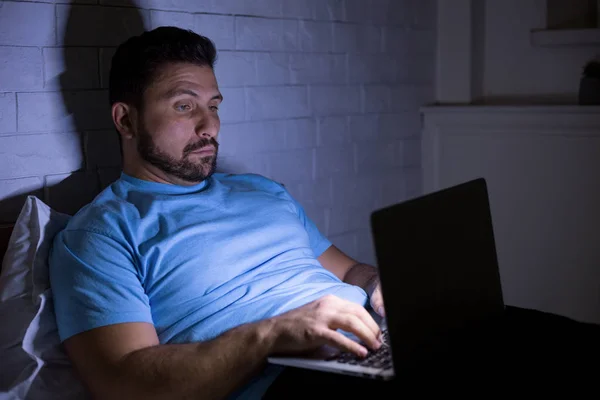 Mann som bruker bærbar datamaskin til hardt arbeid om natten – stockfoto