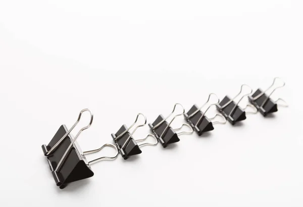 One big office clip leading row of little ones — Stock Photo, Image