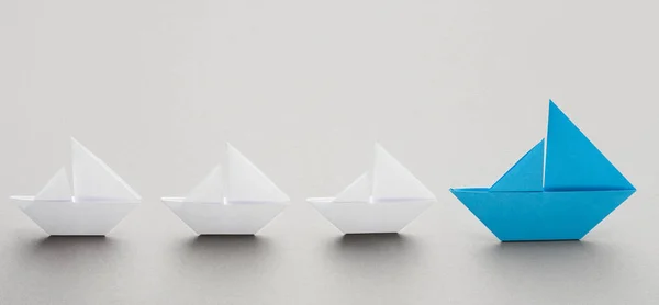 Blue paper boat leading white ships, panorama — Stock Photo, Image