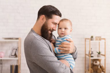 Sevgi dolu babası şirin bebek oğlu kucaklayan