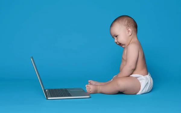 Imádnivaló baba ül a padló és látszó-on laptop képernyő — Stock Fotó